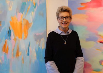 Gerlinde Belz-Küpper vor ihren farbstarken Acrylbildern